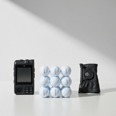 Assortment of modern golf accessories laid out on a clean surface, including a GPS rangefinder, golf balls, and a quality golf glove, with a minimalist background, no text, no words, no typography, clean image