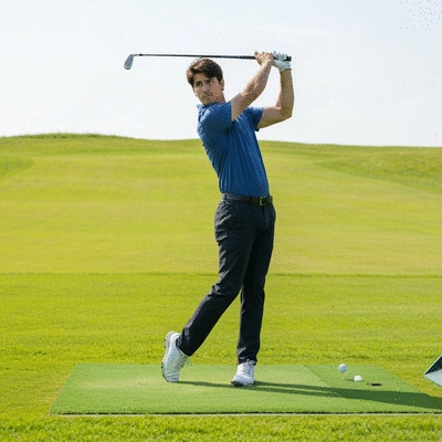 Golfer practicing backswing on a driving range